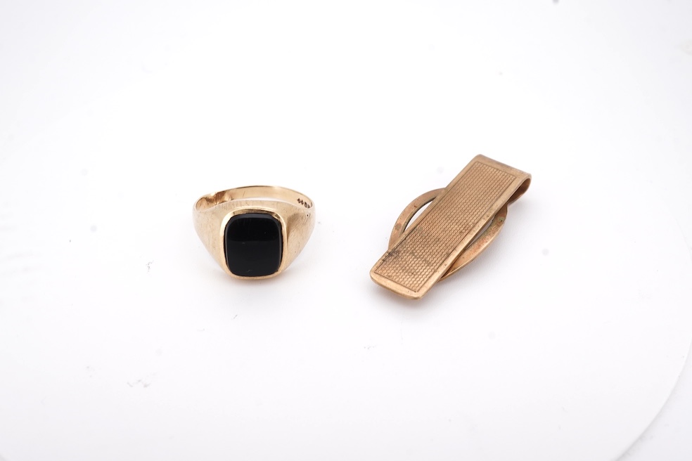 A 1980's 9ct gold tie clip, 39mm and a similar 9ct gold and black onyx set signet ring, gross weight 10 grams.